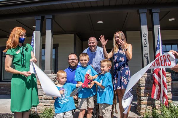 SFC Travis Vendela and his family cut the ribbon outside of his new mortgage-free smart home in Huntsville, Utah