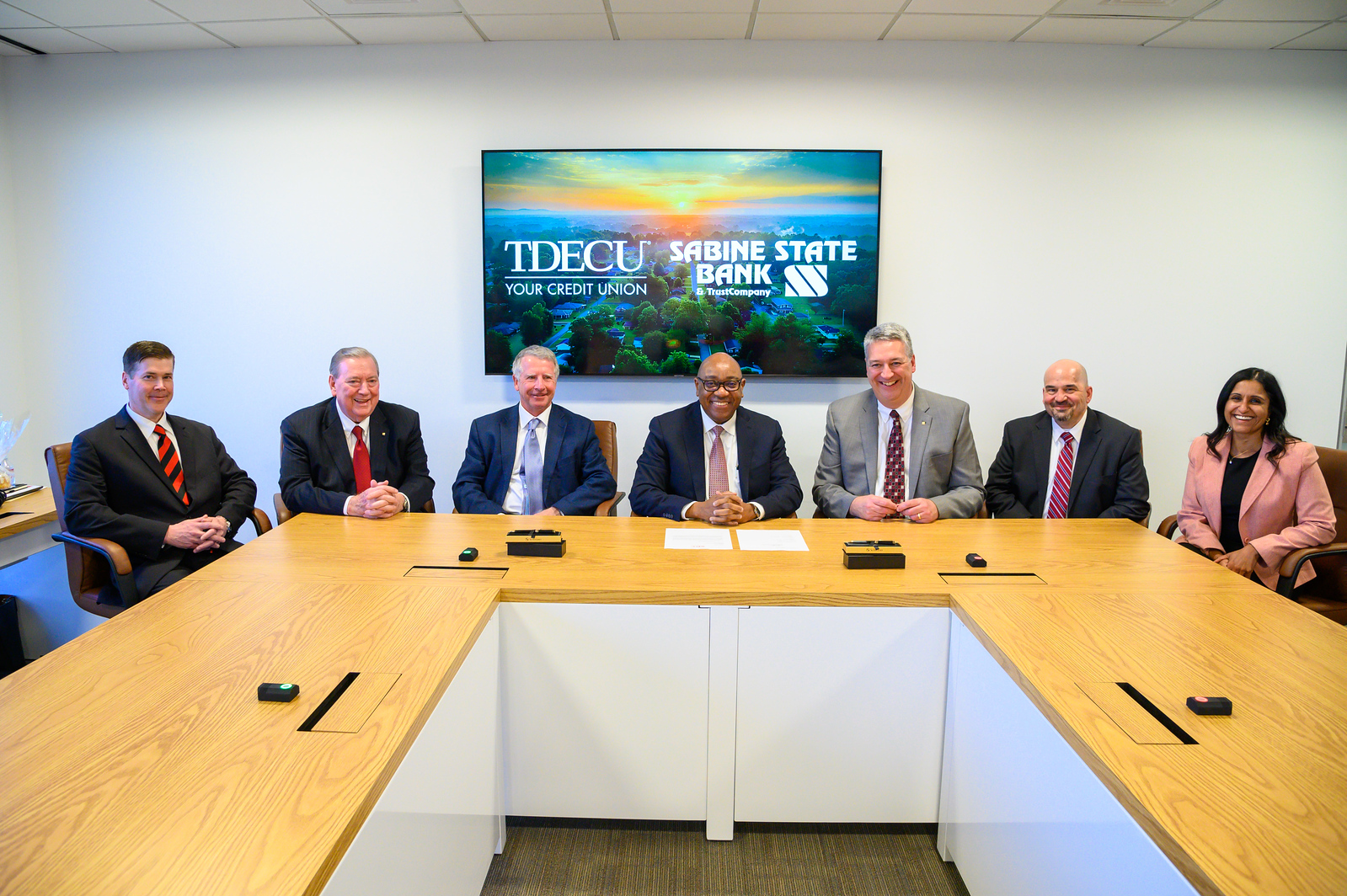 From L to R: Paul Sklar, Chief Financial Officer of Sabine State Bank and Trust; Lee McCann, President and CEO of Sabine State Bank and Trust; Dave Sikora, TDECU Board Chairman; Isaac Johnson, TDECU President and CEO; Jim Cole, Sabine Board Chairman; John Whitehead, General Counsel and Chief Compliance Officer of Sabine State Bank and Trust; Aparna Dave, TDECU Chief Legal Officer and General Counsel