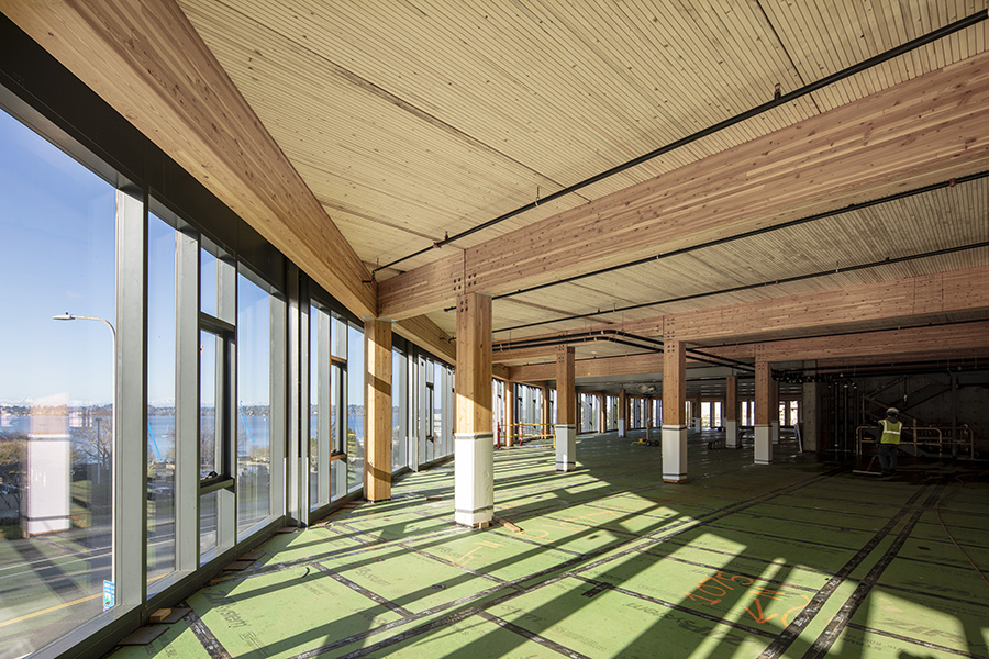 Interior detail view of the new Lakeview Office Building currently under construction in Washington. The all-glass curtainwall exterior with operable windows matches the gentle curve of the site while providing extensive transparency, views of Lake Washington, and a strong connection to the surrounding community. Image: © Adam Hunter/LMN Architects.