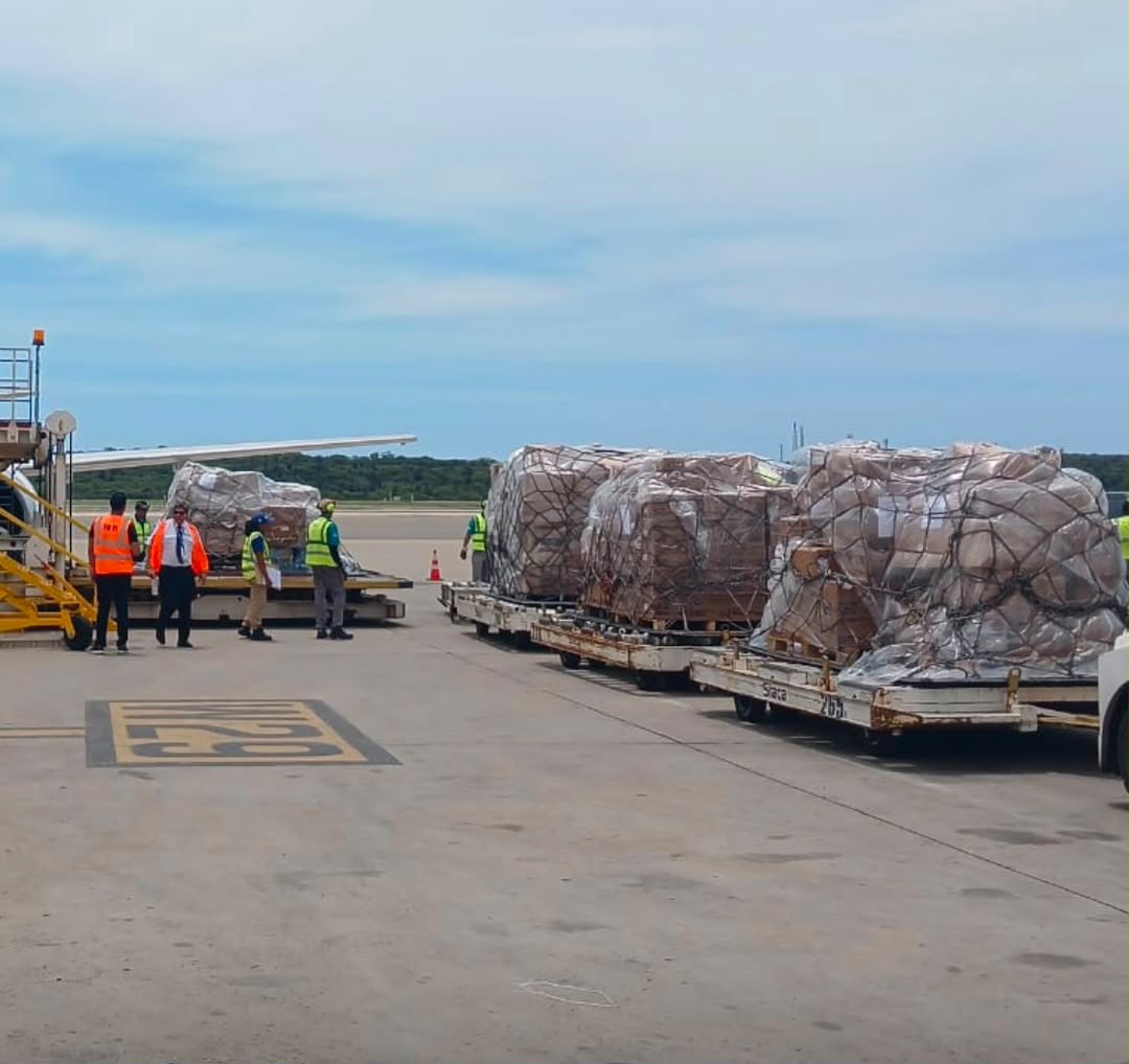 Pallets of emergency relief supplies positioned beside a cargo aircraft before transport to Venezuela.