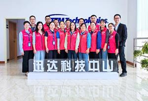 Zhongshan Volunteers Association members in front of the TTM Technologies logo in honor of their award.