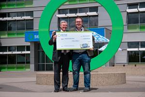 Andrew Buchner and Garth Warner holding the million dollar cheque from the 2019 Servus Big Share Contest